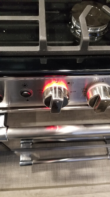 Picture of defective range knob light when burner was off in a new Keystone Montana RV.